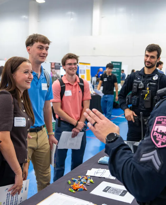 A group of students discusses job opportunities with local police officers