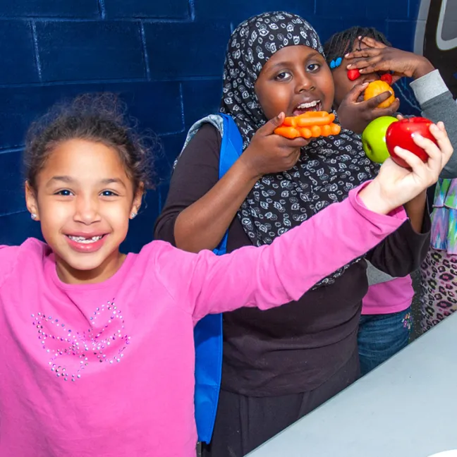 Young children hold healthy foods