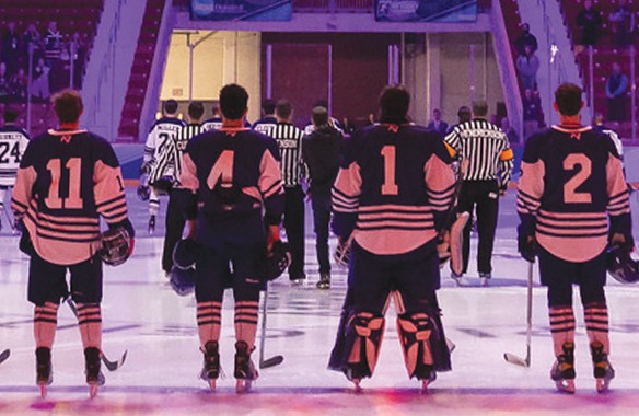 U N E hockey players standing on the ice