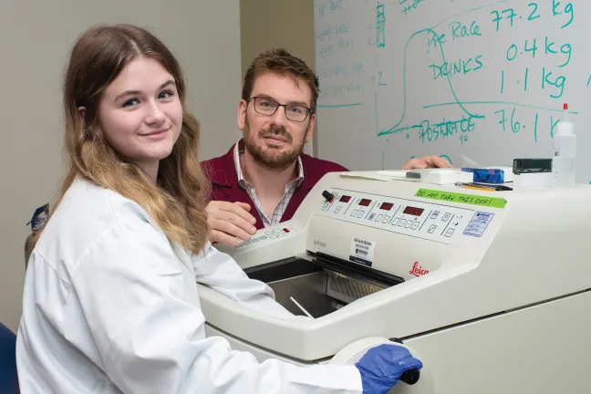 Jayden and Dr. Harrison working with lab equipment