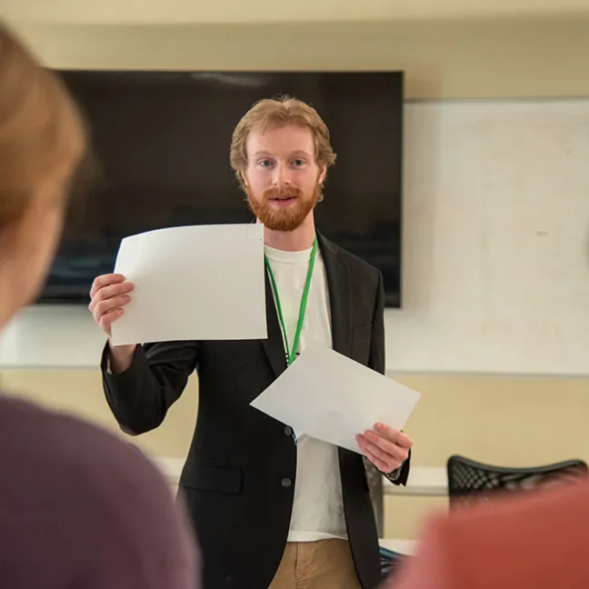 Student holding two pieces of paper