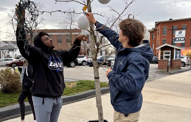 Since 2017, the University of New England students have volunteered to help the Heart of Biddeford non-profit decorate downtown Biddeford with holiday lights. This year, the light brigade showed up in force on Nov. 16 as 28 students climbed ladders up and down Main Street to help hang lights and decorate the town for the holidays.
