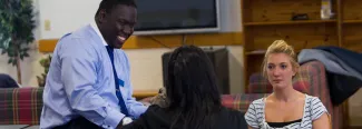 U N E tutor speaking with two students