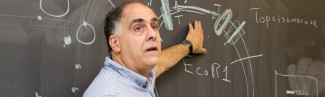 a faculty member draws on a blackboard