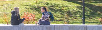 students sit outside during fall on the biddeford campus