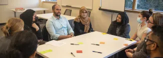 People talk with each other at a roundtable about cultural competencies in health care