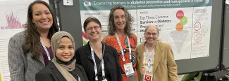 UNE researchers pose in front of a poster they presented at the American Public Health Association’s 150th Anniversary Annual Meeting