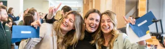 Three female students hug after learning their residency matches