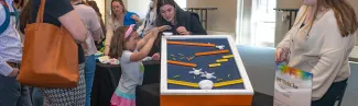 A child plays with an adaptive toy at a display table