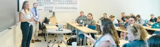 Conference attendees gather for a session in a UNE classroom