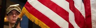An Army ROTC member holds an American flag