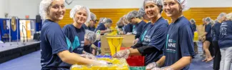 Students help make Meals for Maine food kits.