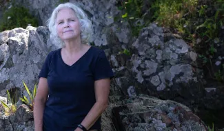 UNE's Pam Morgan poses against a rocky outcropping