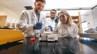UNE faculty member Sri Mohan works with students in his lab