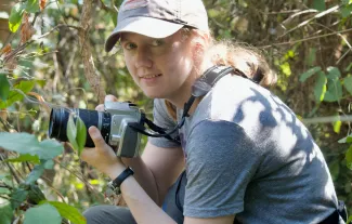 UNE faculty member Maggie Stanton holds a camera in Gombe National Park