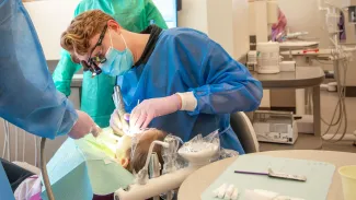 A UNE dental student performs a cleaning for a local schoolchild 