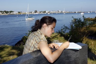 U N E student studying by the ocean
