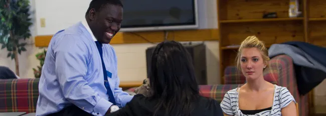 U N E tutor speaking with two students