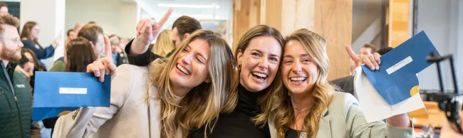 Three female students hug after learning their residency matches