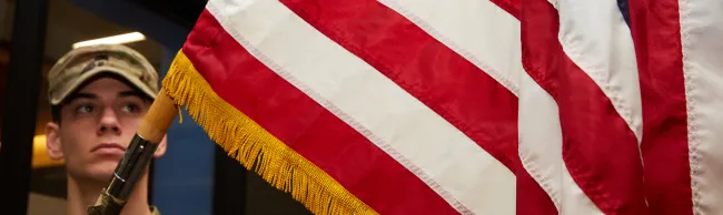 An Army ROTC member holds an American flag