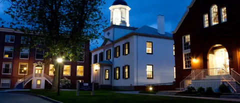 exterior of three buildings at night on the u n e portland campus