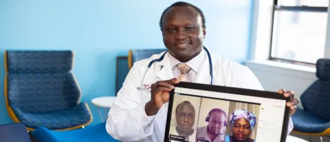 Malual Mabur with computer screen of Facebook Live session