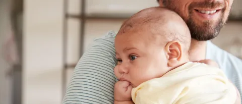 A man holds an infant 