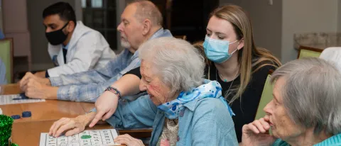 Samantha Morgan (D.O., ’25) plays bingo with a resident of The Cedars in Portland