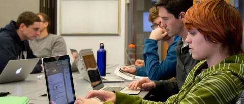 Students taking notes on their laptops during class lecture