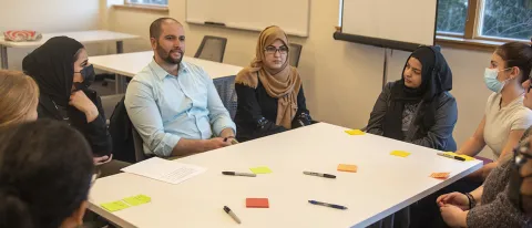 People talk with each other at a roundtable about cultural competencies in health care