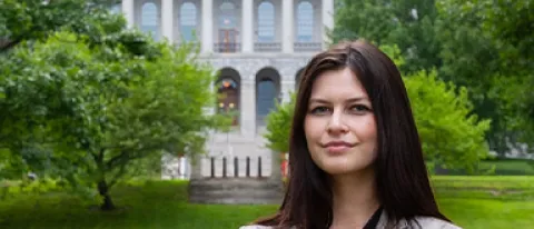 Image of Kiara Frischkorn posing for portrait in front of Maine State House