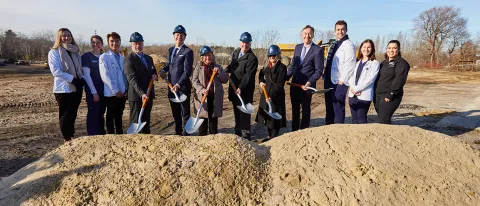 UNE leadership dig into the earth at the groundbreaking ceremony for the Harold and Bibby Center for Health Sciences on Tuesday, Nov. 29, 2022