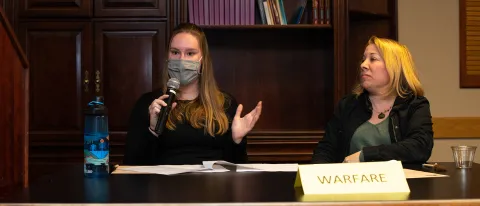 Meghan Hanks speaks at the debate while teammate Candace Baker looks on.