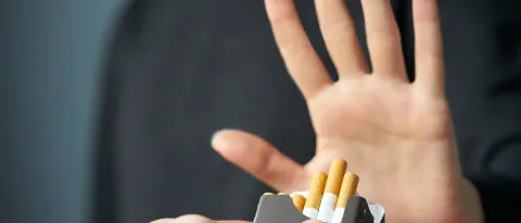 Stock image of a person raising their hand "no" to an offer for a cigarette