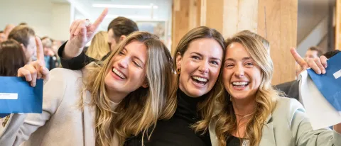 Three female students hug after learning their residency matches
