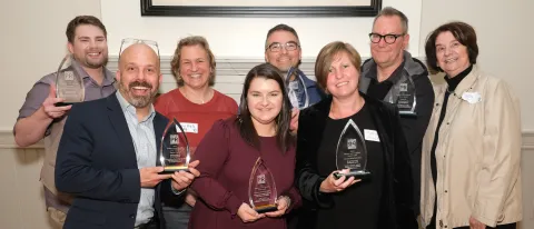 Members of UNE's Communications Office pose with their Golden Arrow awards