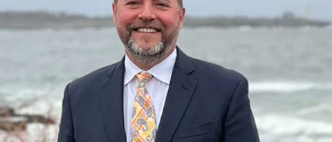 Portrait of Jim Irwin smiling with the ocean in the background