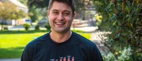 Robert Motley poses for a portrait on the quad outside UNE's Parker Pavilion. He wears a shirt that reads "Superhumans," which is the name of the clinic he volunteered at in Ukraine.