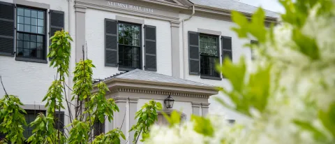 A photo of flowers on the Portland Campus with Alumni Hall in the background