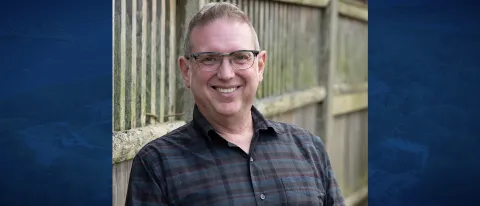 Portrait of Joshua Chard against a blue backdrop overlaid with a campus aerial