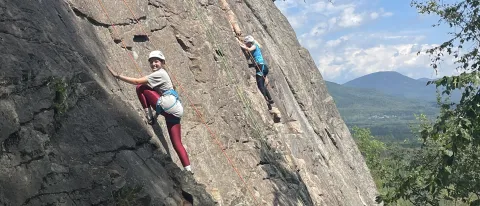 Students scale a mountain using ropes
