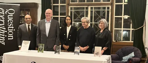 A photo of the prize finalists standing behind a table bearing the Royal Institute of Philosophy's name and logo