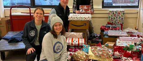 Members of UNE's Pediatrics Club and Sigma Sigma Phi pose with a variety of wrapped presents they plan to donate