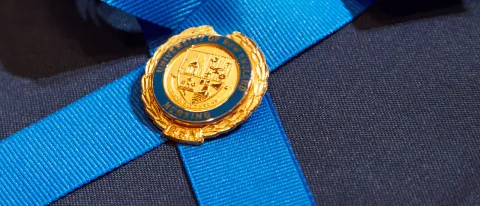 A nursing pin with the UNE crest