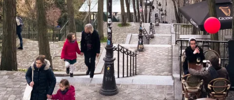 Photo of people walking up and down steps and sitting at cafe tables