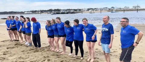 Members of the UNE community line up on Freddy Beach to jump into the Saco River