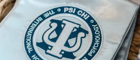 A photo of a stole bearing the PSI CHI logo