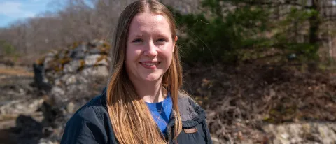 Portrait of a woman smiling in front of the forest