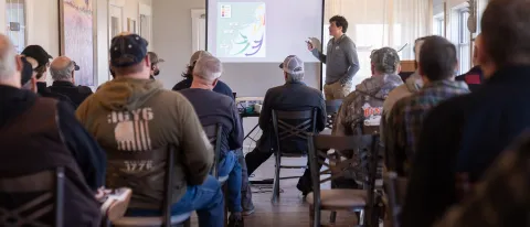 A student presents a slideshow to a room of people