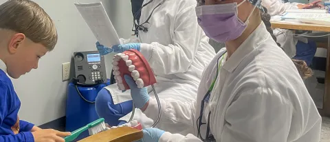 Dental Hygiene students and faculty interact with a family at a local WIC center